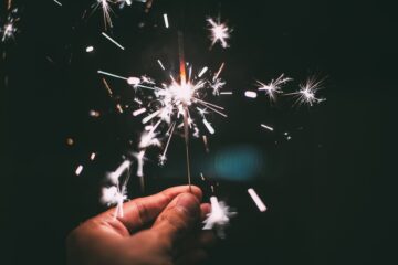 person holding firecracker at night